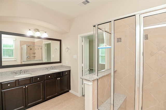 full bathroom featuring a sink, a stall shower, double vanity, and visible vents