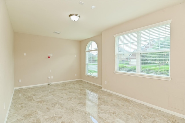 unfurnished room featuring baseboards and visible vents