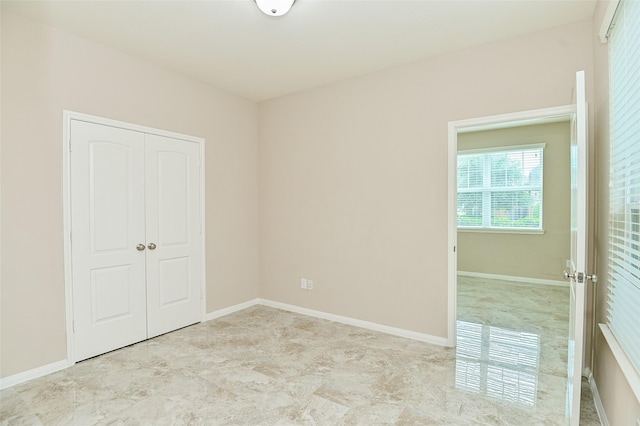 unfurnished bedroom with baseboards and a closet