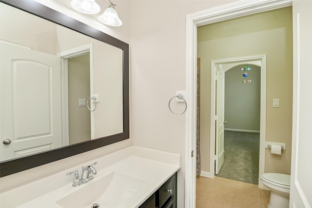 bathroom with vanity, tile patterned flooring, baseboards, and toilet