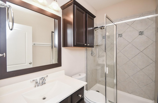 bathroom featuring vanity, a stall shower, and toilet