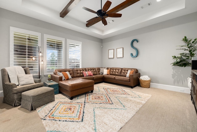 living room featuring visible vents, baseboards, a tray ceiling, a ceiling fan, and carpet