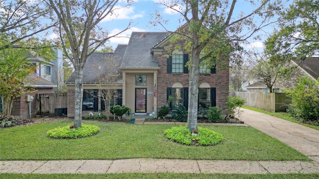 2021 Caravel Dr, League City, TX 77573 - traditional-style home with brick siding, a front lawn, roof with shingles, and fence