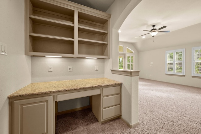 interior space featuring ceiling fan, light colored carpet, lofted ceiling, and built in study area