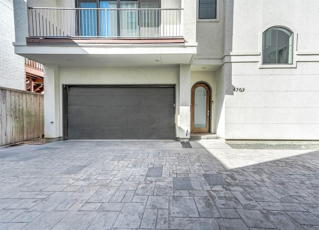4707 Jackson St, Houston, TX 77004 - property entrance featuring a garage, stucco siding, a balcony, fence, and decorative driveway