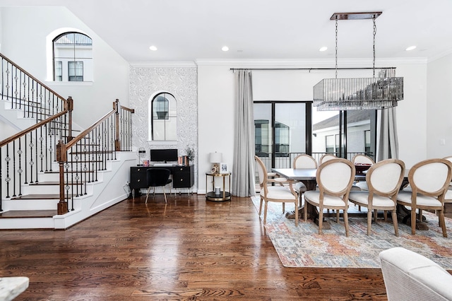 dining room featuring ornamental molding, a healthy amount of sunlight, stairway, and wood finished floors
