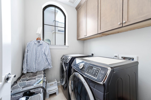 clothes washing area with cabinet space, separate washer and dryer, and visible vents