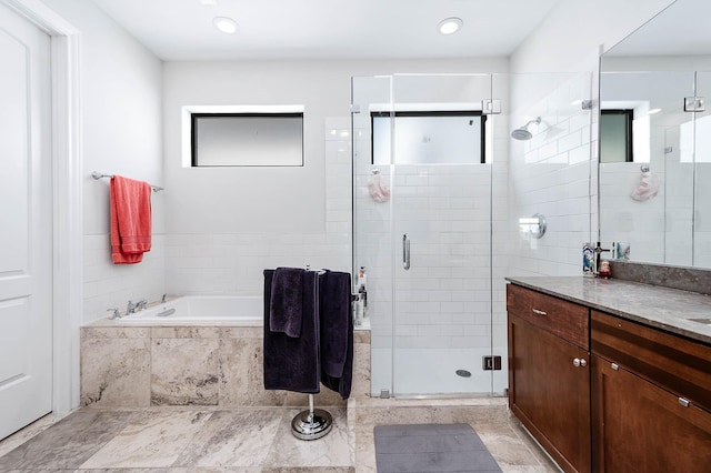 bathroom featuring a garden tub, a stall shower, and vanity