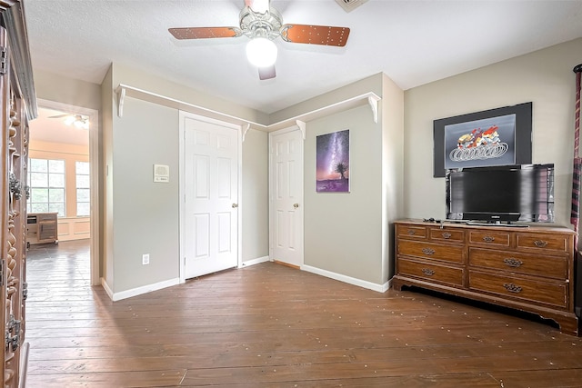 bedroom with baseboards, ceiling fan, and dark wood-style flooring