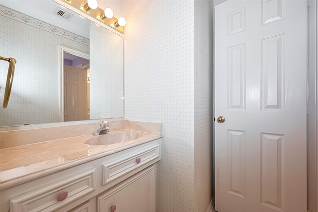 bathroom with vanity, wallpapered walls, and visible vents