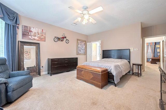 bedroom featuring baseboards, a ceiling fan, and light carpet