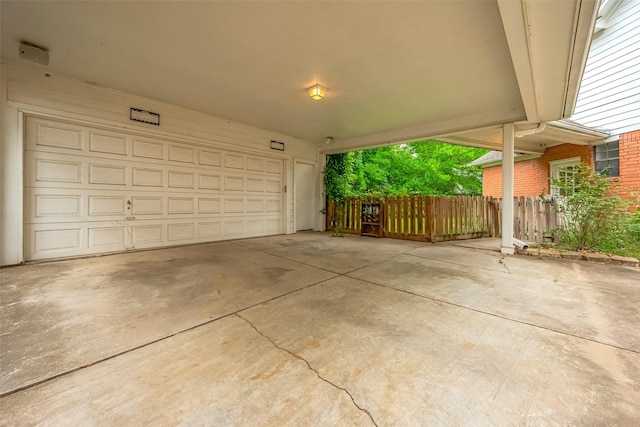 garage with fence and driveway