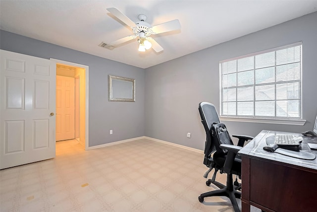 home office with ceiling fan, visible vents, baseboards, and light floors