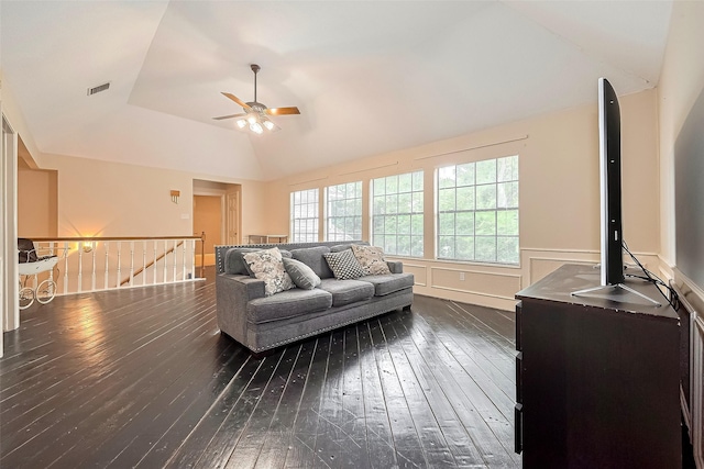 living room featuring ceiling fan, a wainscoted wall, lofted ceiling, dark wood-type flooring, and visible vents