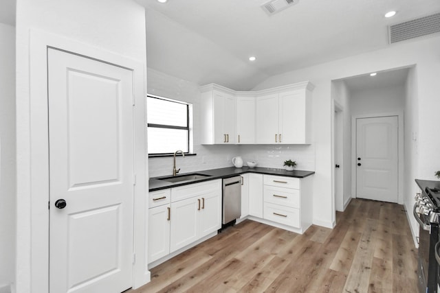 kitchen featuring visible vents, a sink, appliances with stainless steel finishes, and vaulted ceiling