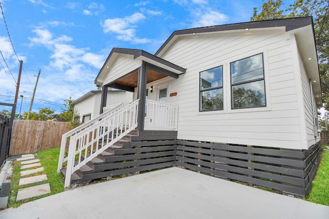 view of front of property featuring a patio and fence