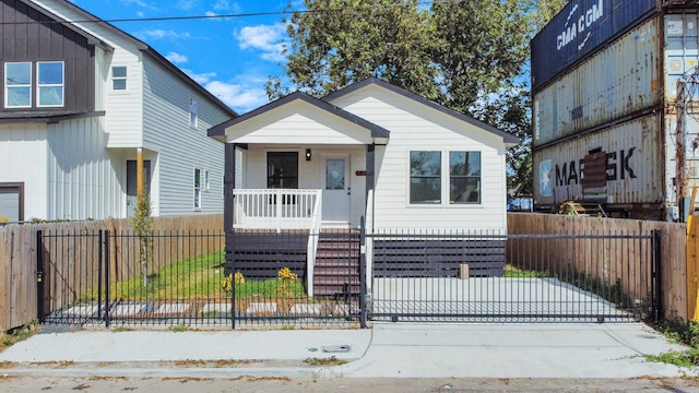 bungalow featuring a gate, a fenced front yard, and covered porch
