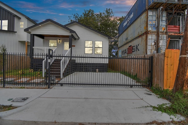 view of front of property featuring a gate, a fenced front yard, and a porch