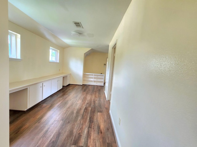 additional living space featuring baseboards, dark wood-style floors, and visible vents
