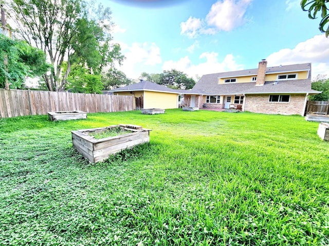 view of yard featuring fence and a vegetable garden