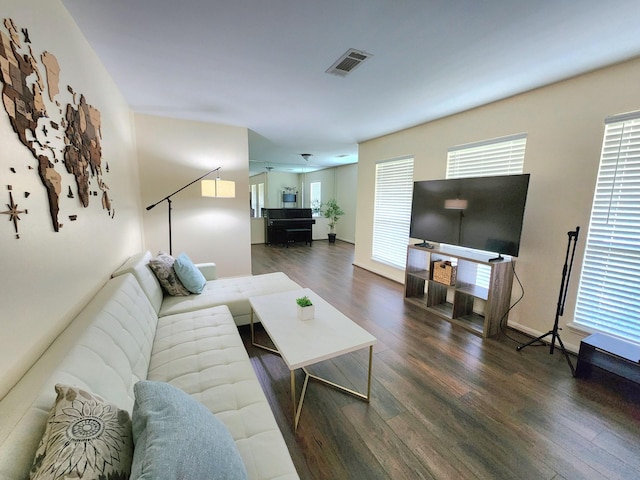 living area with a healthy amount of sunlight, wood finished floors, and visible vents