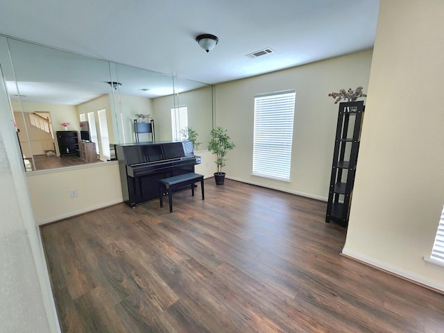 living area featuring baseboards, wood finished floors, and visible vents