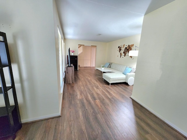 living area with baseboards and wood finished floors