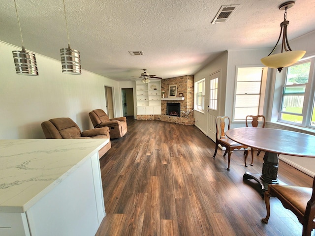 living room with a healthy amount of sunlight, dark wood-style flooring, and visible vents