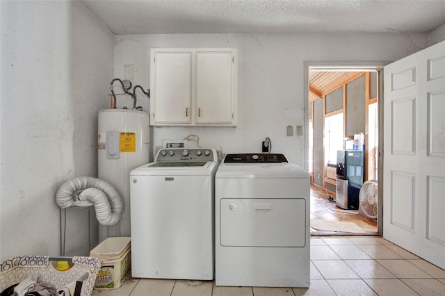 laundry area with light tile patterned flooring, a textured ceiling, cabinet space, independent washer and dryer, and water heater