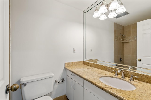 full bath featuring vanity, a notable chandelier, toilet, and tiled shower