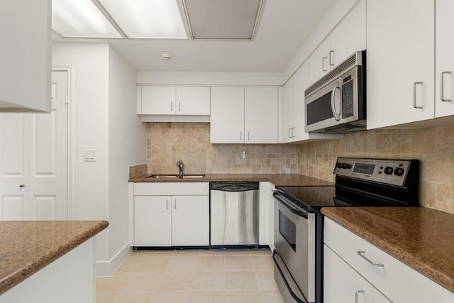 kitchen with a sink, decorative backsplash, white cabinetry, and stainless steel appliances