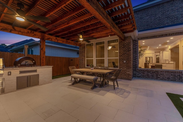 view of patio with fence, outdoor dining area, ceiling fan, and area for grilling