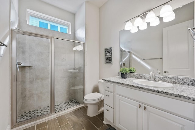 full bathroom with vanity, toilet, and a shower stall