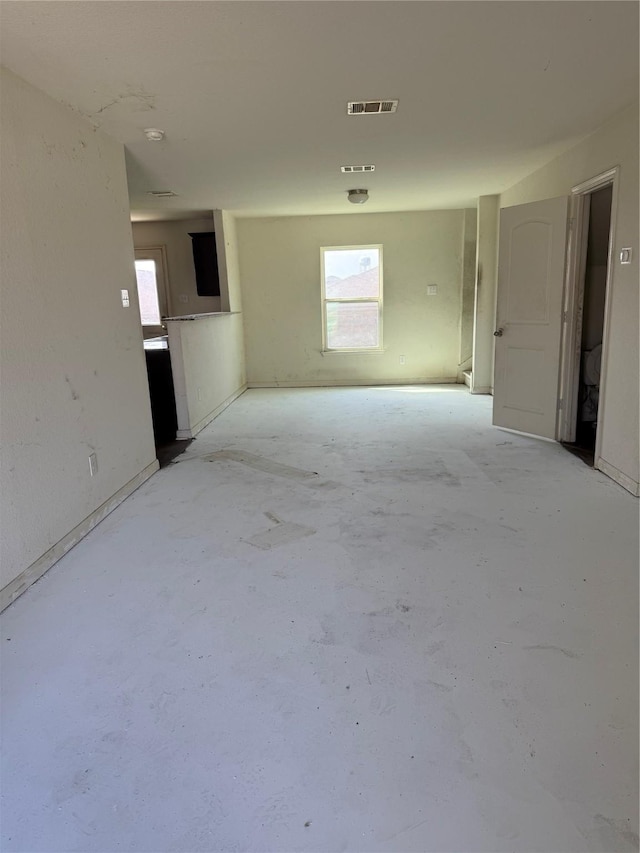 unfurnished room featuring a healthy amount of sunlight, concrete floors, and visible vents