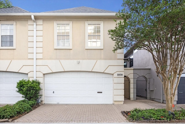 view of front of house with an attached garage, driveway, and stucco siding