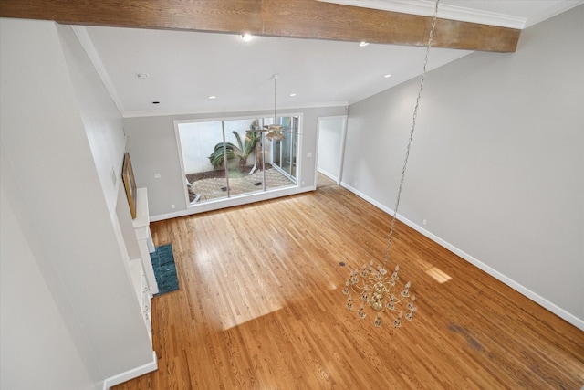 unfurnished living room featuring crown molding, baseboards, and wood finished floors