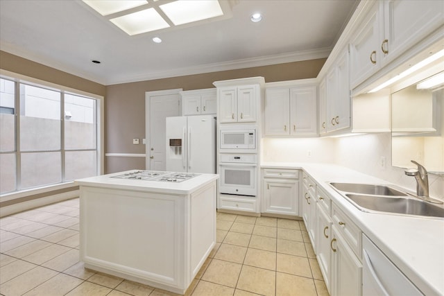 kitchen with a kitchen island, white appliances, white cabinets, a sink, and light tile patterned floors