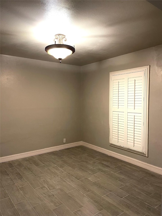 spare room with baseboards and wood tiled floor