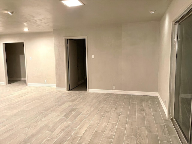 empty room featuring baseboards, recessed lighting, and light wood-style flooring