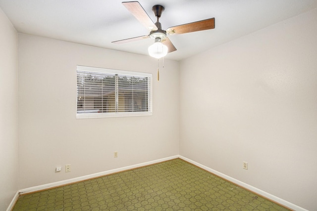unfurnished room featuring baseboards, a ceiling fan, and dark colored carpet