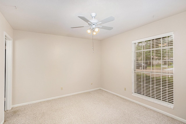 empty room featuring baseboards, ceiling fan, and carpet
