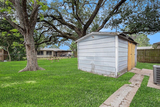 view of yard with an outbuilding, fence, a storage shed, and cooling unit