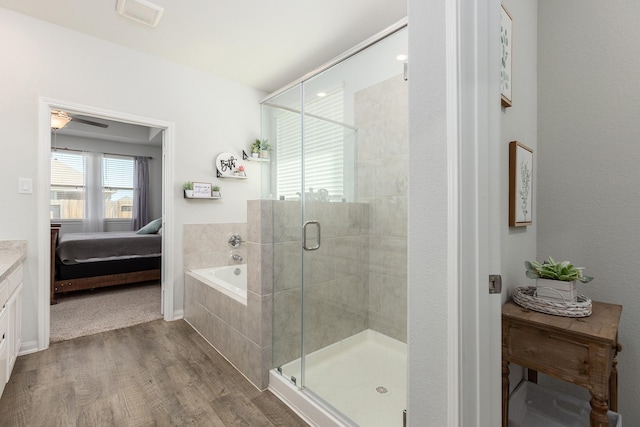 15727 Ty Cobb Ct, Splendora, TX 77372 - ensuite bathroom featuring connected bathroom, wood finished floors, a bath, and a stall shower
