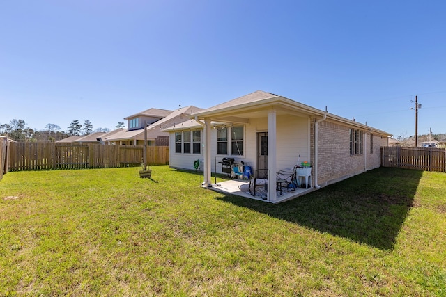 15727 Ty Cobb Ct, Splendora, TX 77372 - back of house featuring a lawn, a fenced backyard, brick siding, and a patio