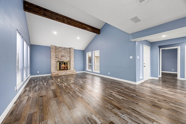unfurnished living room with baseboards, vaulted ceiling with beams, wood finished floors, and visible vents