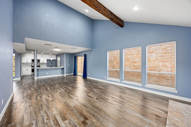 unfurnished living room with high vaulted ceiling, baseboards, and dark wood-style flooring