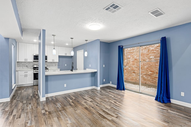 kitchen featuring light countertops, stove, dark wood-style flooring, and visible vents