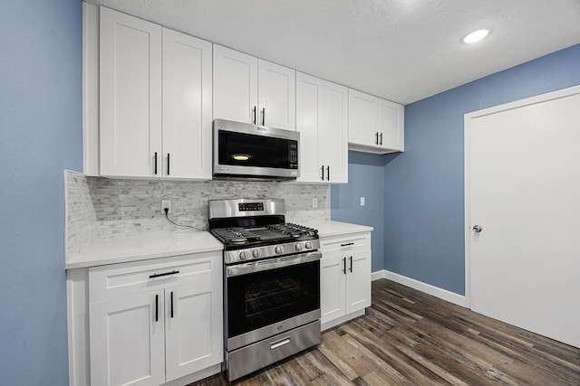 kitchen with decorative backsplash, dark wood-style flooring, baseboards, white cabinetry, and stainless steel appliances