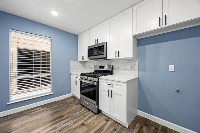 kitchen featuring light countertops, baseboards, decorative backsplash, and stainless steel appliances