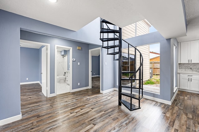 interior space featuring dark wood finished floors, baseboards, and stairs